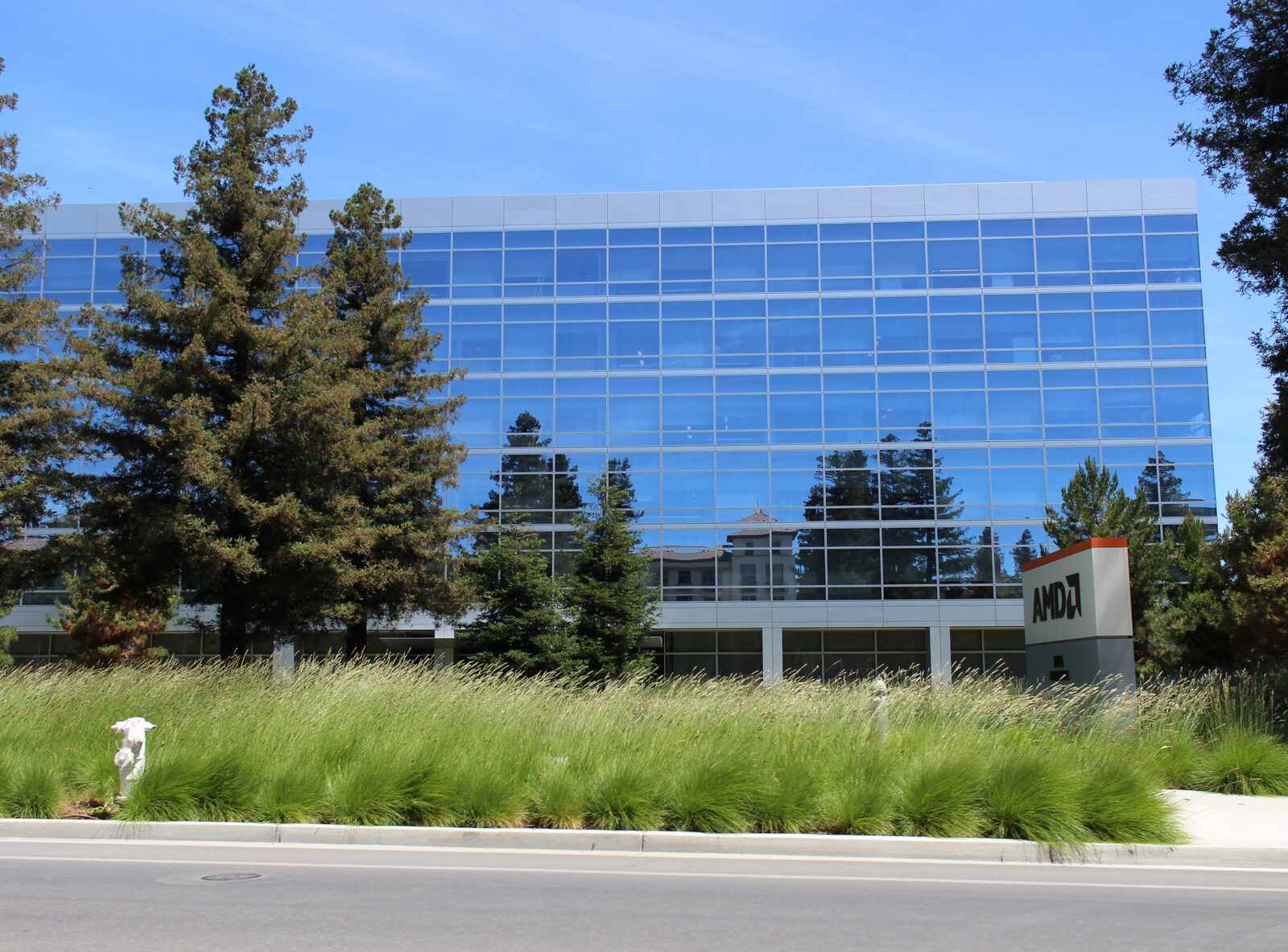 AMD'nin Kaliforniya Santa Clara'daki cam cepheli genel merkez binası ve önündeki AMD tabelası