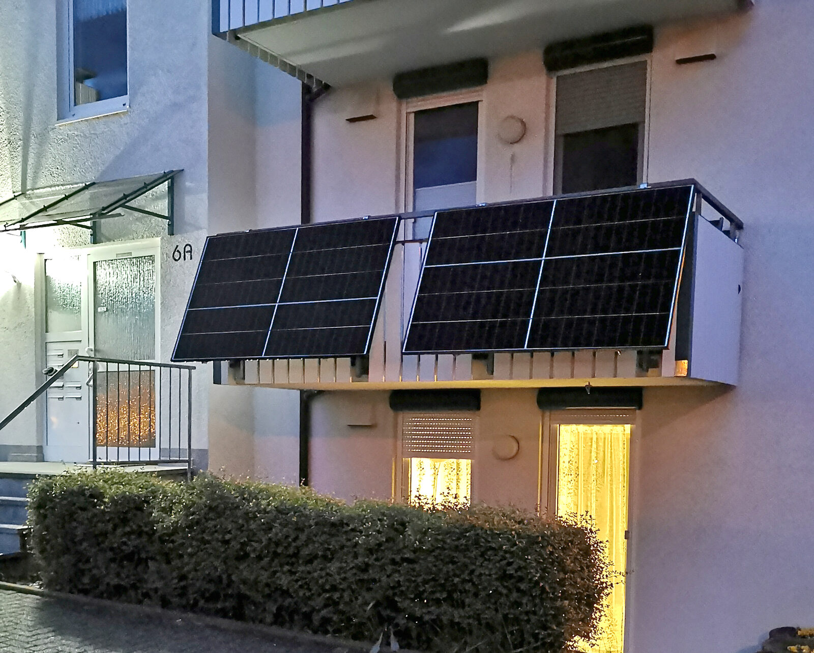 Zwei Solarmodule eines Balkonkraftwerks an einem Balkongeländer eines Mehrfamilienhauses