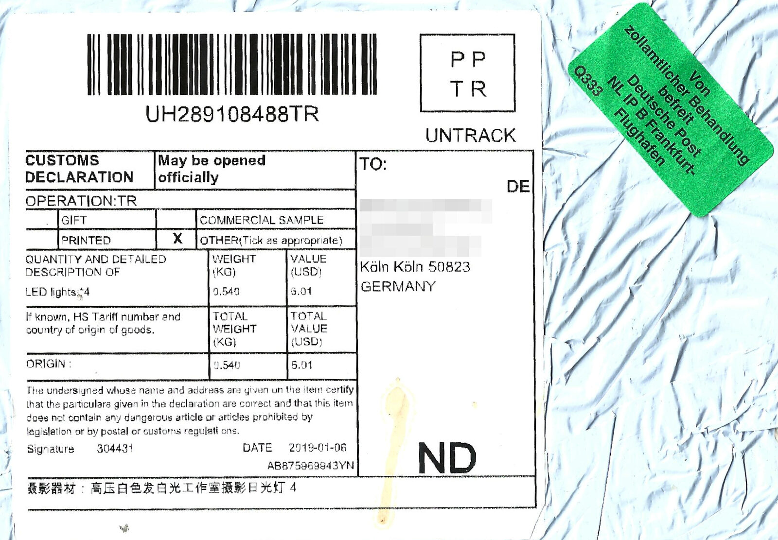Paketaufkleber einer Sendung aus China nach Köln mit Zollinhaltserklärung und grünem Aufkleber der Deutschen Post zur Befreiung von der zollamtlichen Behandlung