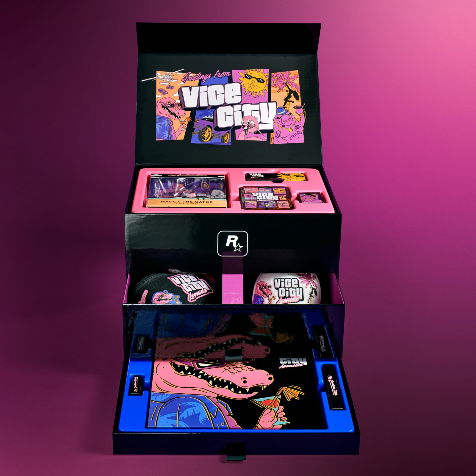 Geopende zwarte verzamelbox van de GTA VI Vice City Collection met Macca-figuur, pet, tas en poster in roze vakken
