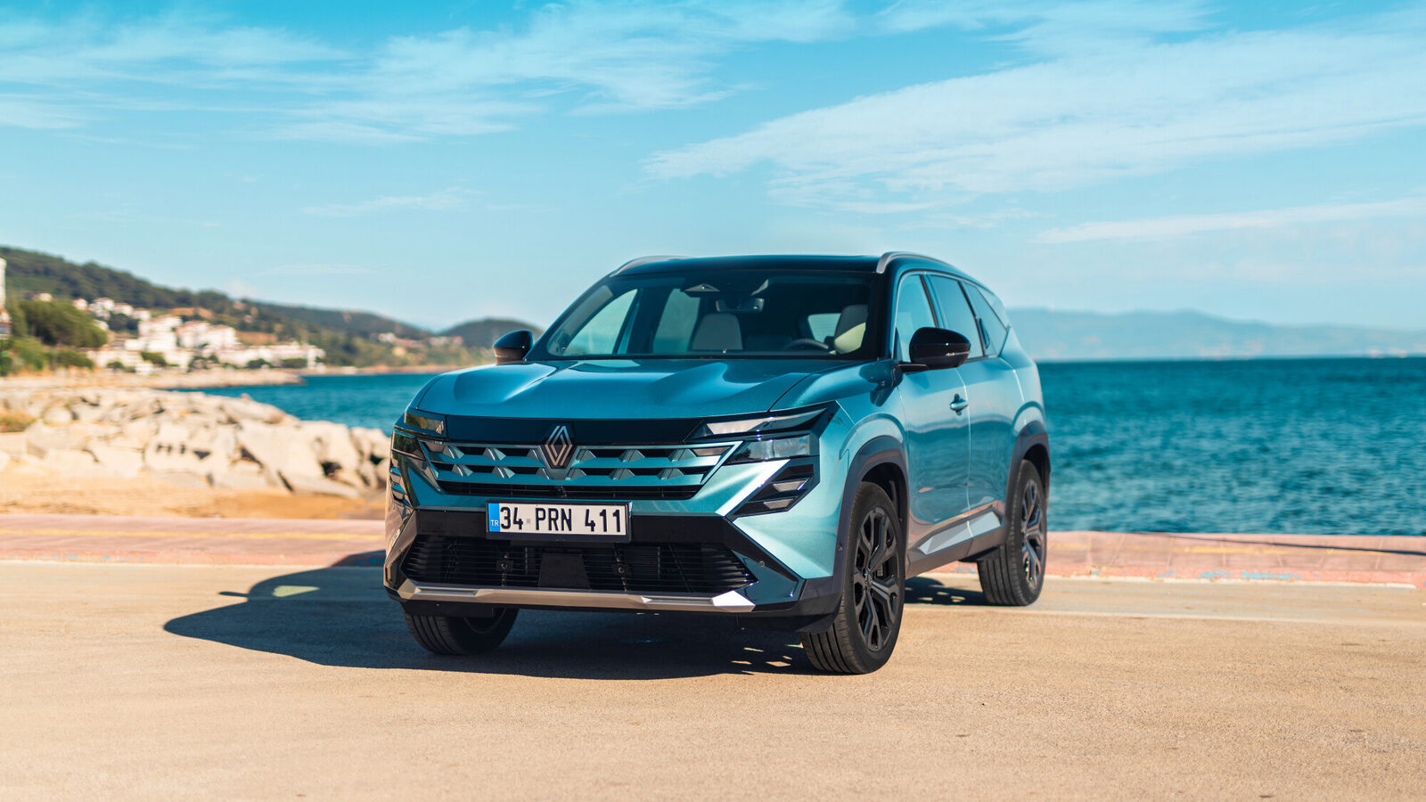 Mavi-yeşil Renault Boreal sahilde önden çapraz görünüm