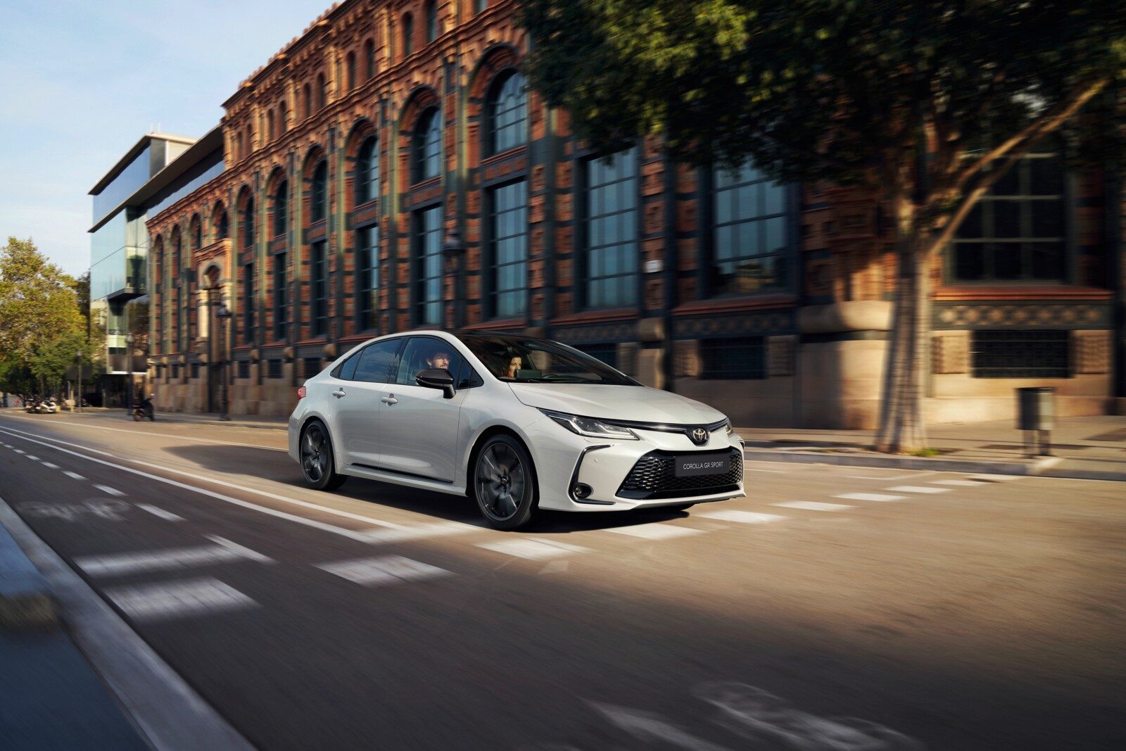 Beyaz Toyota Corolla sedan şehir içinde önden çapraz görünüm