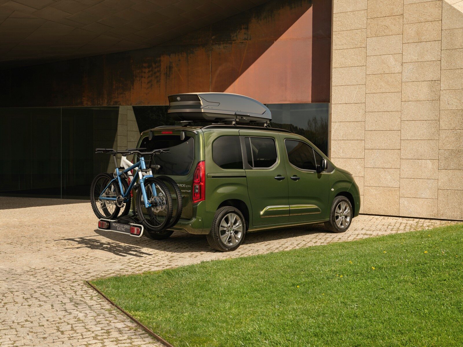 Yeşil Toyota Proace City arkadan çapraz görünüm, bisiklet taşıyıcılı