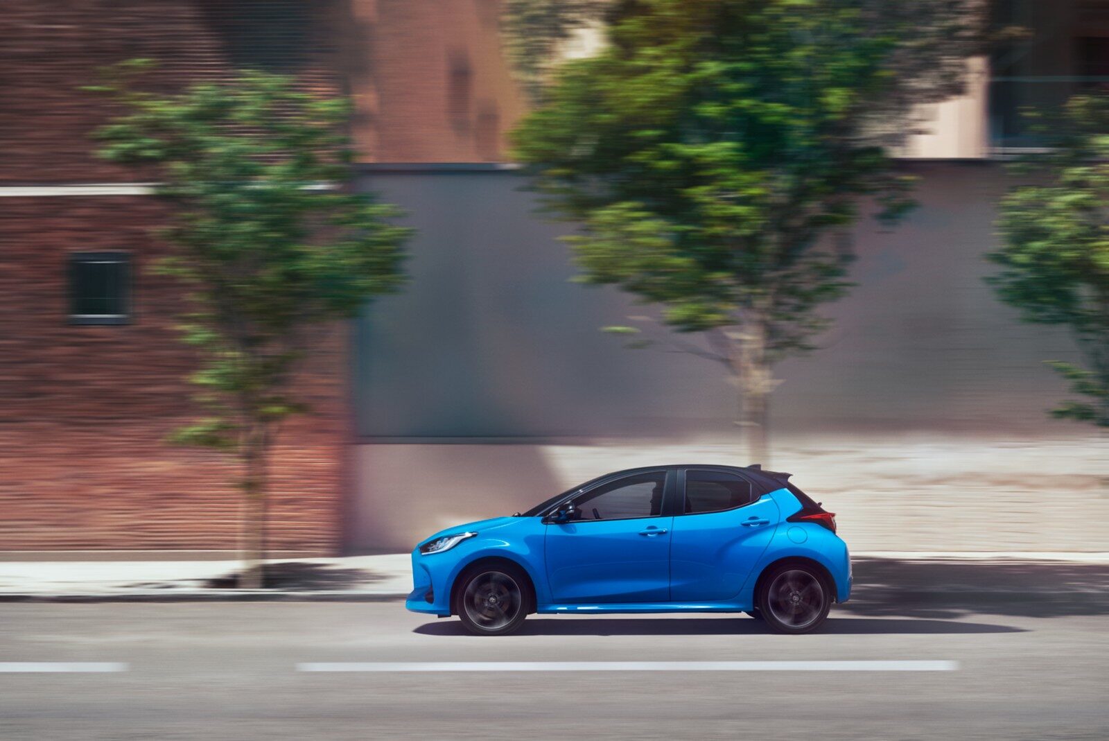 Mavi Toyota Yaris yandan seyir halinde