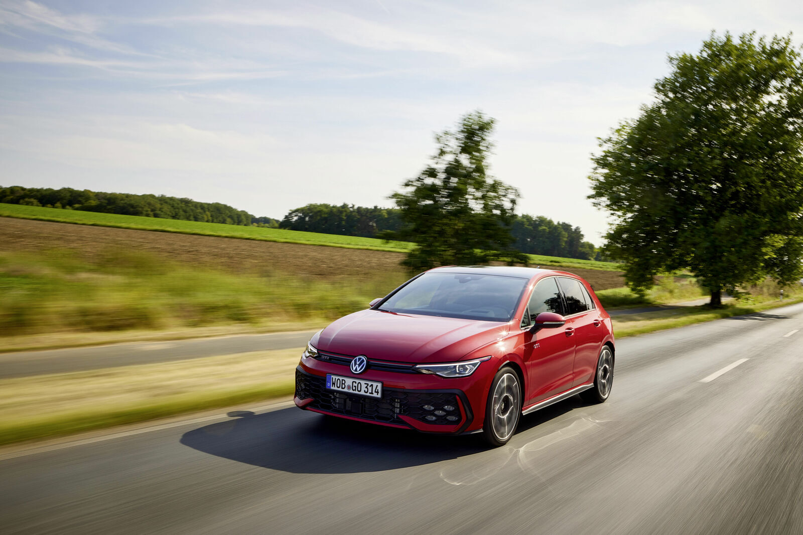 Kırmızı Volkswagen Golf GTI, kırsal yolda hareket halinde