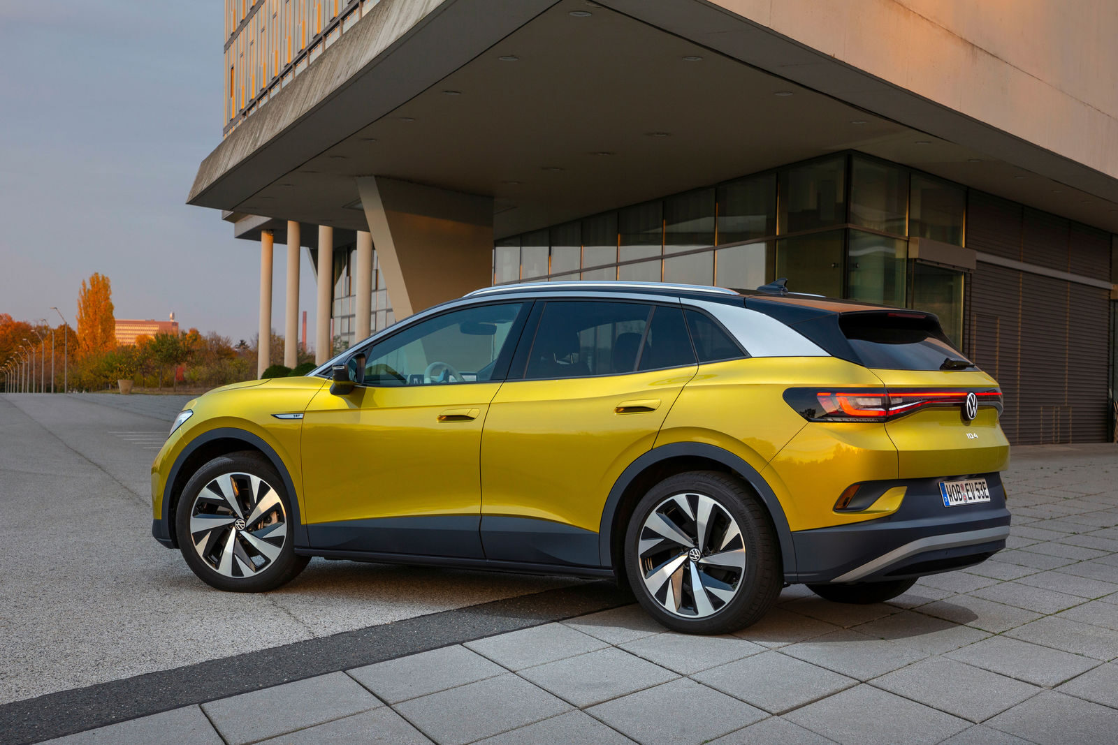 Sarı Volkswagen ID.4, bina önünde yandan-arkadan görünüm