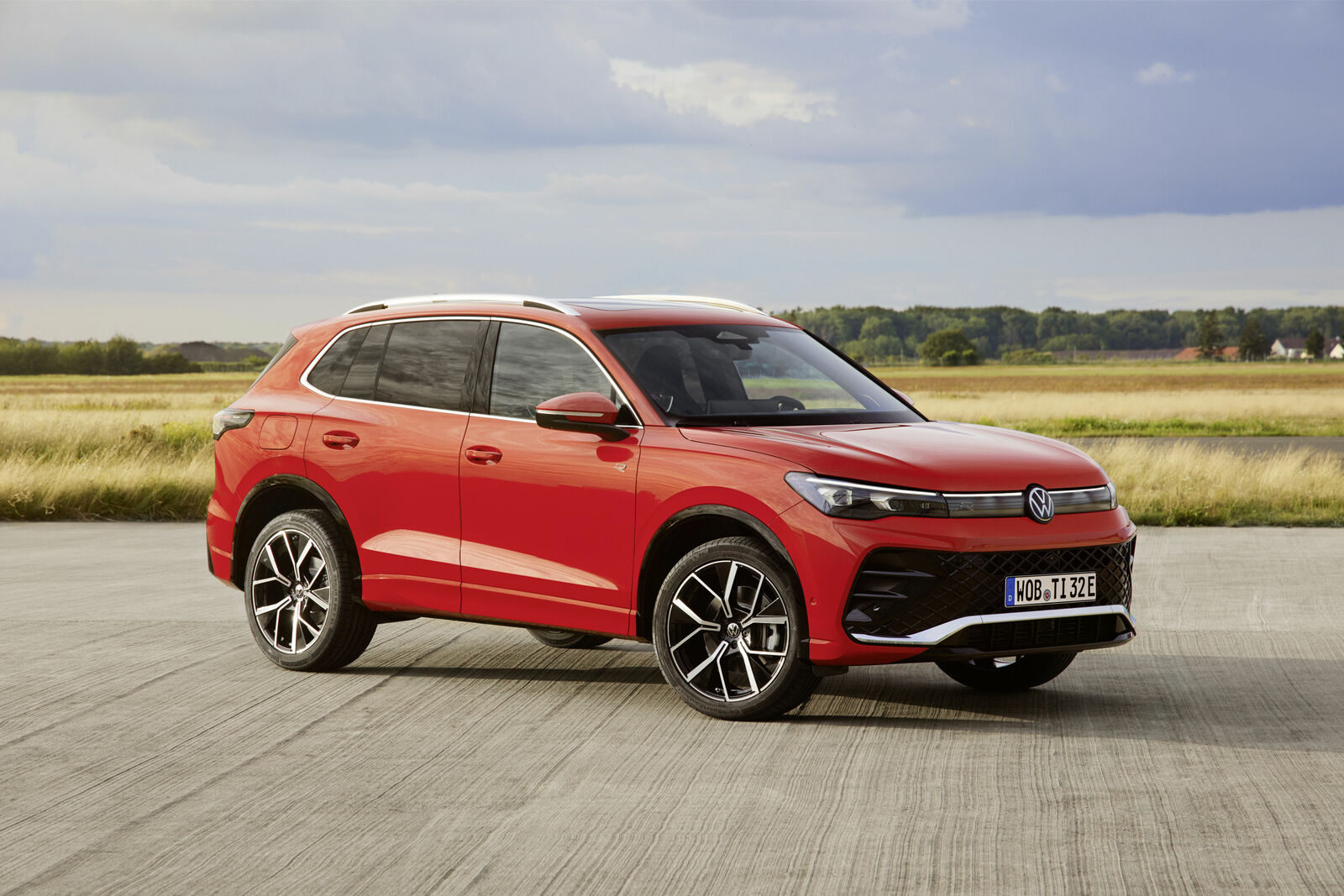 Kırmızı Volkswagen Tiguan, açık bir alanda önden-yandan görünüm