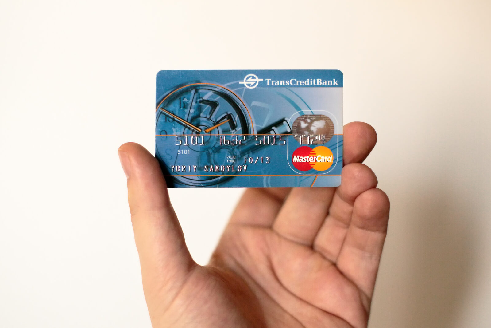 Hand hält eine Mastercard-Kreditkarte vor hellem Hintergrund
