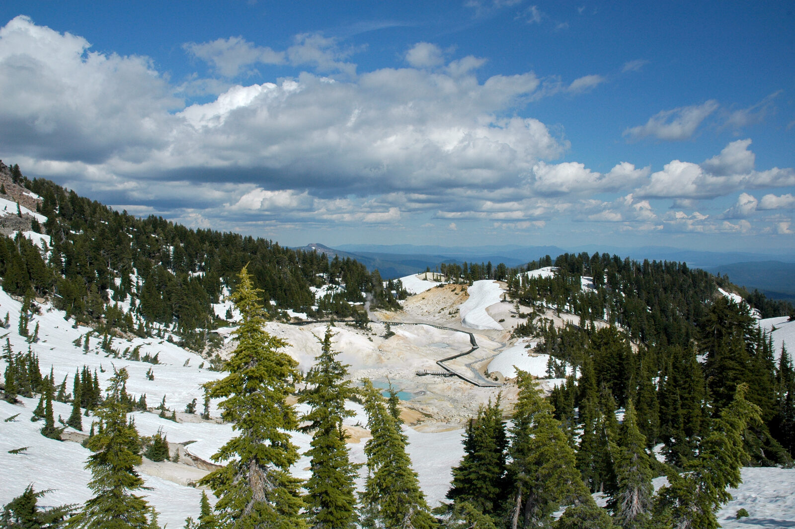 Lassen Volkanik Milli Parkı'ndaki Bumpass Hell jeotermal alanı; buharı tüten sıcak su kaynakları ve karla kaplı yamaçlar (temsilî, örneklerin alındığı tam nokta değil)