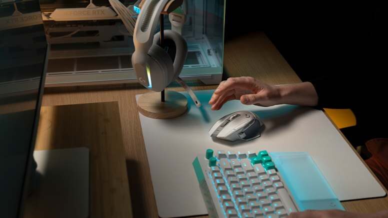 Logitech G502 X Plus auf einem Schreibtisch neben Headset und Tastatur