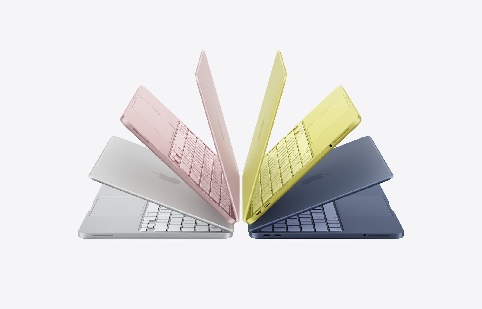 Vier aufgeklappte MacBook Neo in Silber, Rosa, Gelb und Dunkelblau