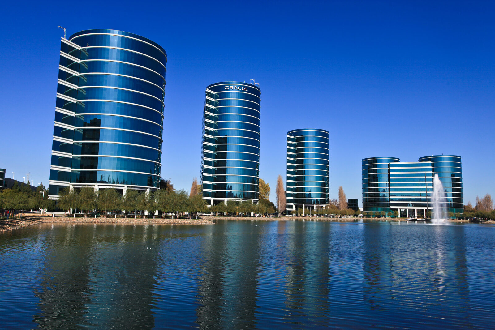 Die runden, verglasten Bürotürme der Oracle-Zentrale in Redwood Shores an einem See mit Fontäne