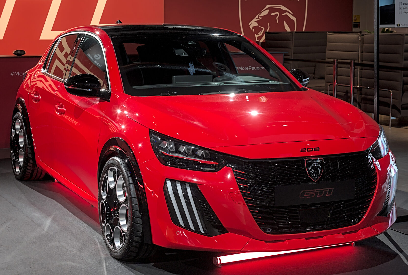 Auto Zürich 2025 fuarında sergilenen kırmızı Peugeot E-208 GTi'nin önden görünümü