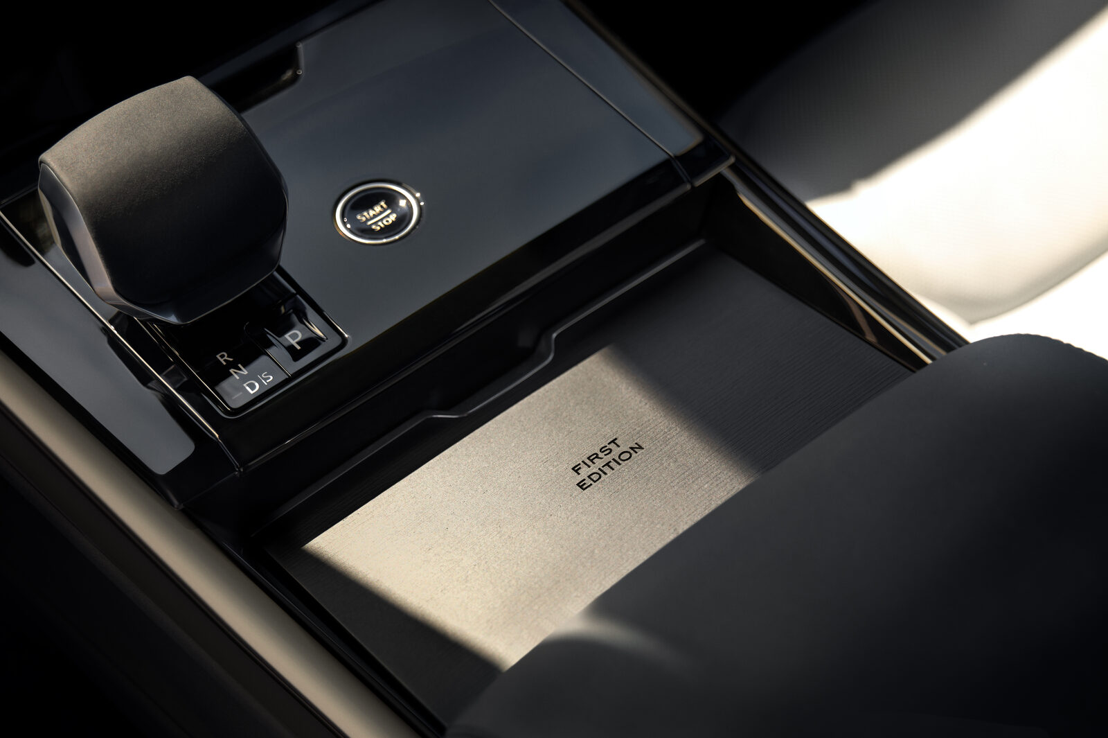 Görsel: JLR Range Rover Sport Electric First Edition'ın orta konsolu: vites kolu, start-stop düğmesi ve "First Edition" yazılı metal panel