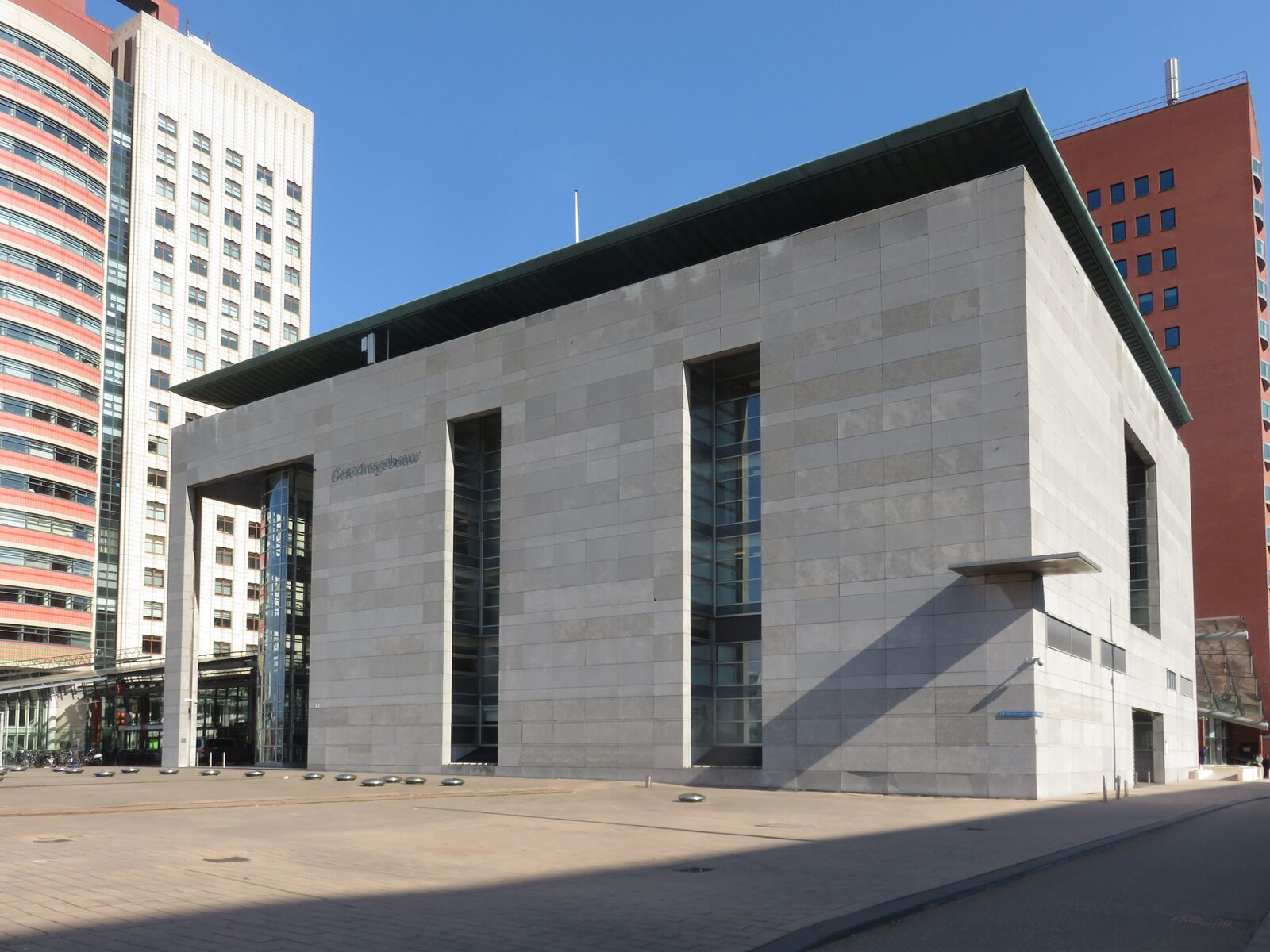Het grijze gerechtsgebouw van de Rechtbank Rotterdam aan het Wilhelminaplein onder een blauwe lucht