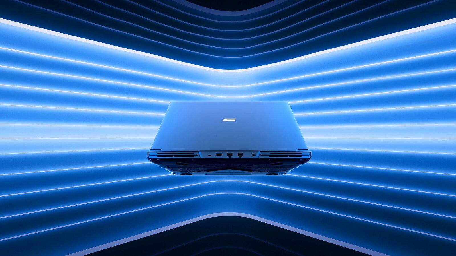 Das Notebook Schenker Key 18 Pro von hinten vor blau beleuchtetem Hintergrund
