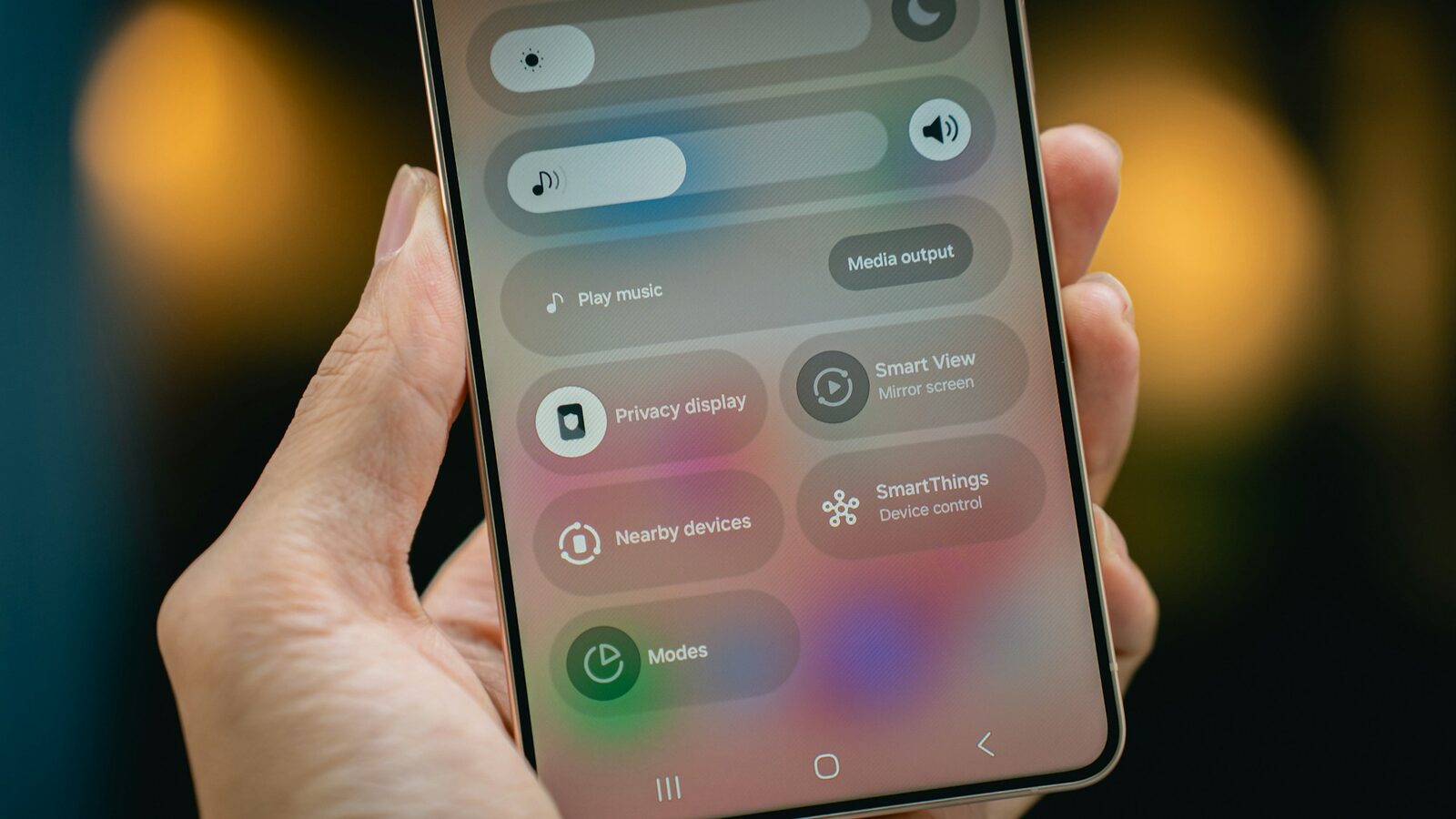 Hand hält ein Android-Smartphone mit geöffneten Schnelleinstellungen, darunter die Kachel „Privacy display“
