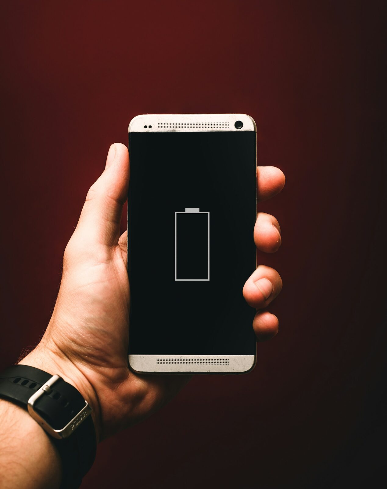 Elde tutulan akıllı telefonun ekranında boş pil simgesi