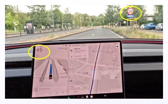 Lo schermo di una Tesla indica 45 km/h mentre fuori si vede un cartello con limite di 30