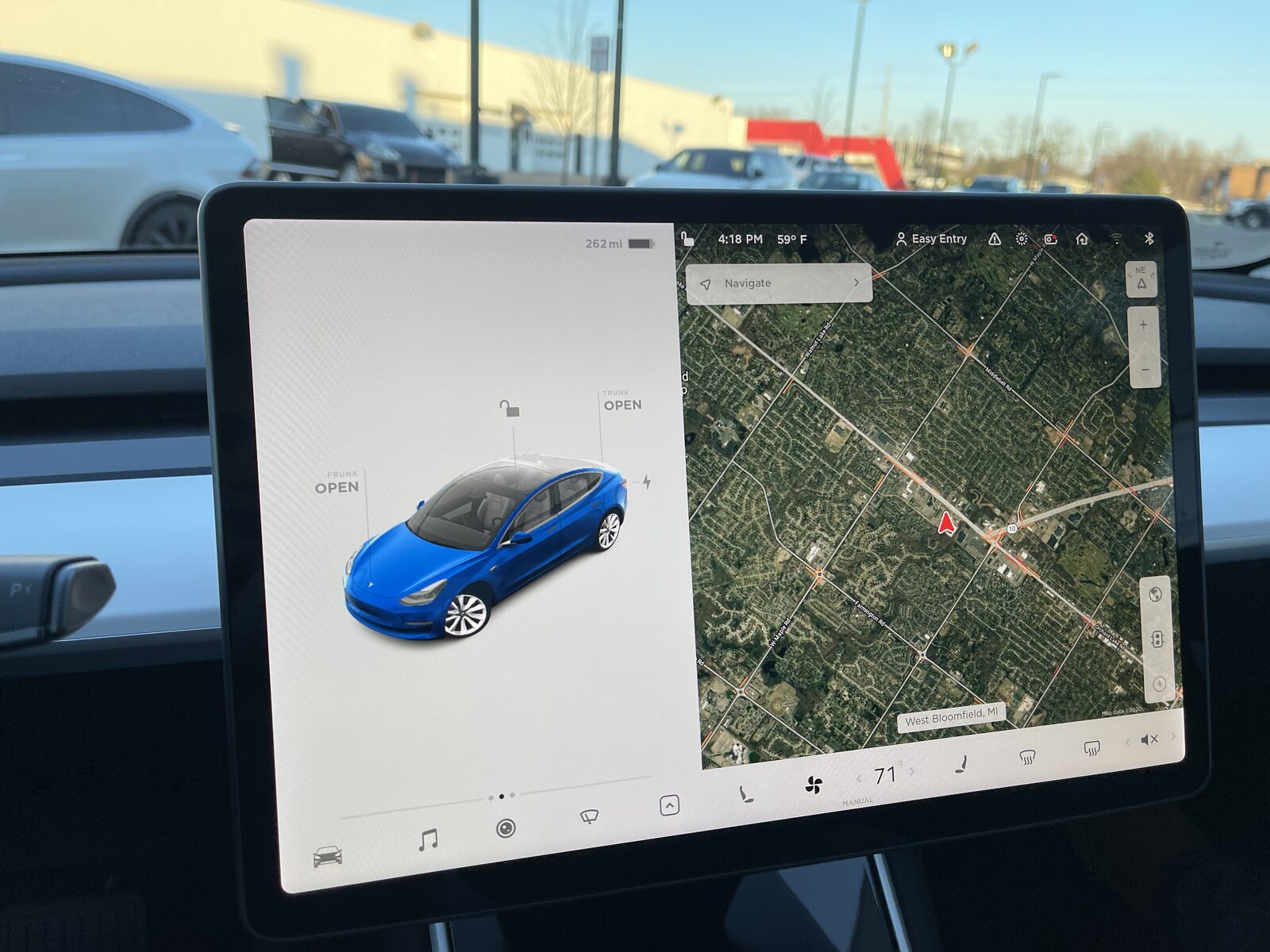 Tesla Model 3'ün orta konsoldaki 15,4 inçlik dokunmatik ekranı, solda araç görünümü sağda uydu haritası
