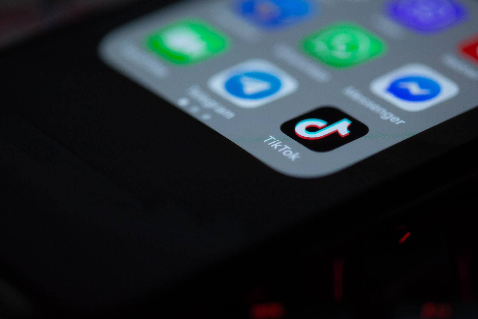 Das TikTok-App-Symbol auf dem Startbildschirm eines Smartphones, daneben Telegram und Messenger