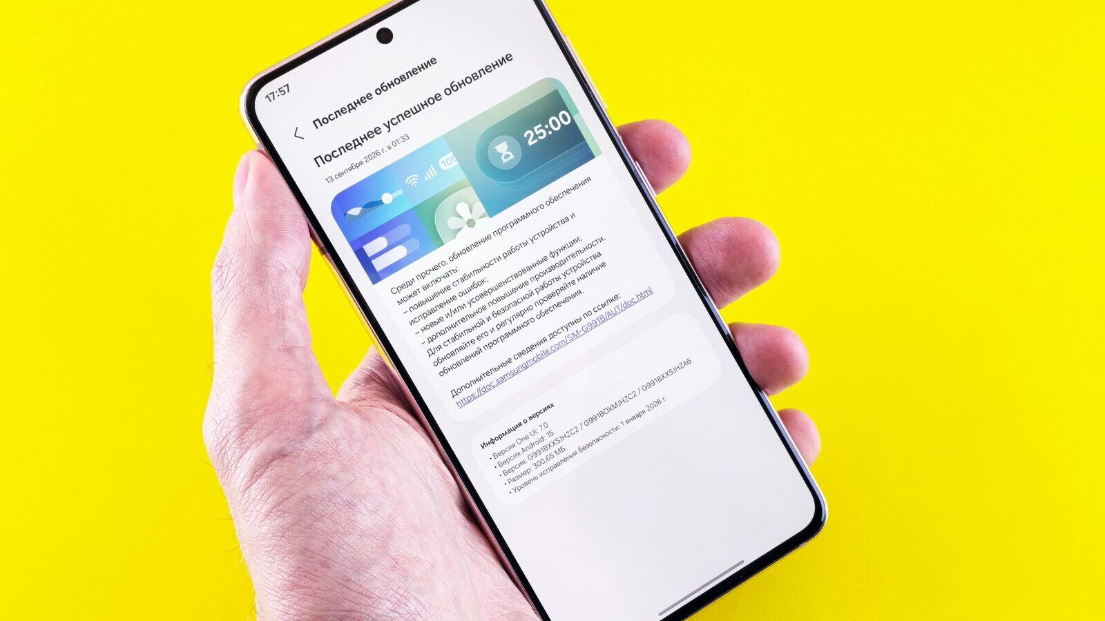 Hand hält ein Smartphone mit geöffnetem Software-Update-Bildschirm vor gelbem Hintergrund
