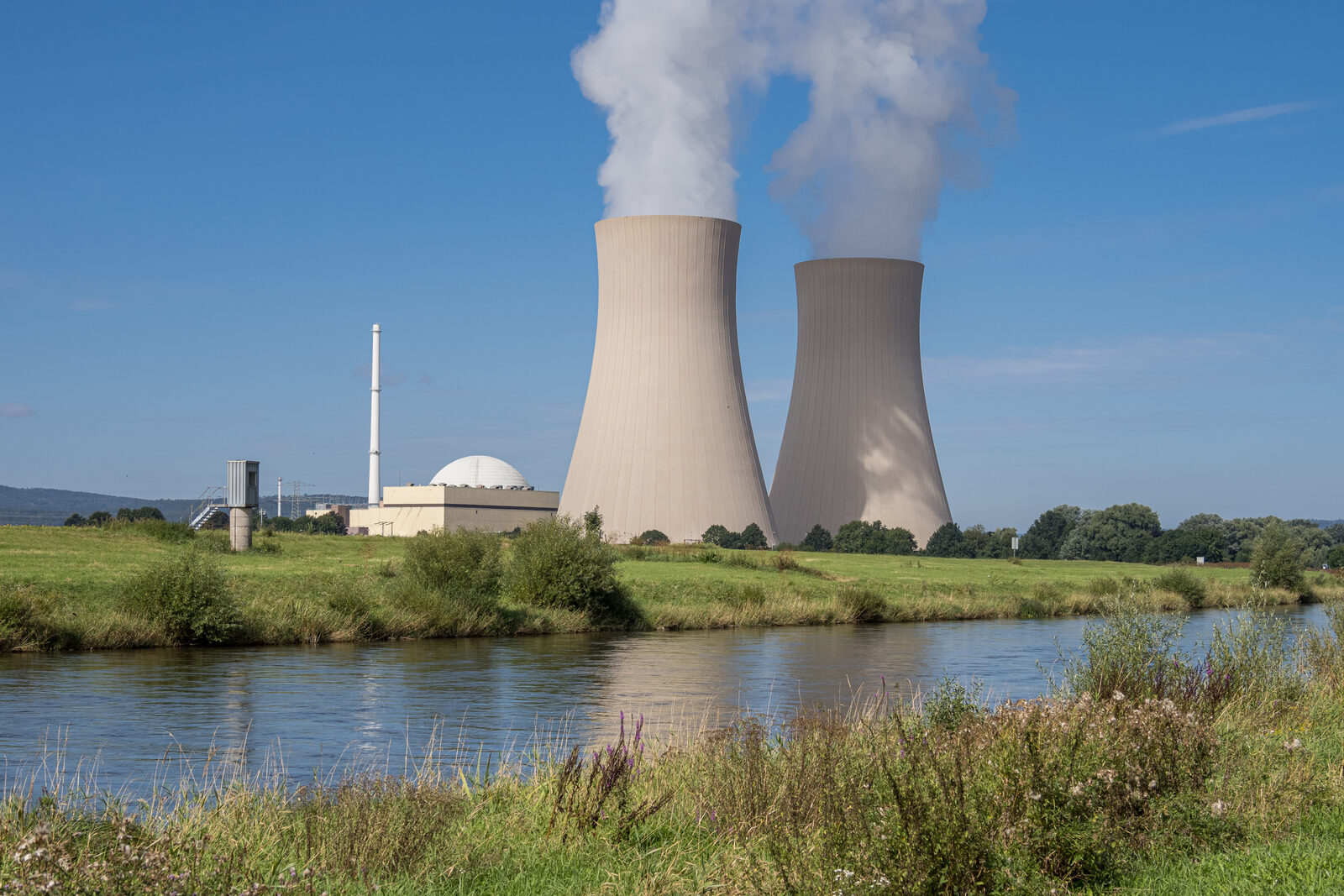 Das Kernkraftwerk Grohnde mit Kühltürmen am Ufer der Weser, aufgenommen im August 2021