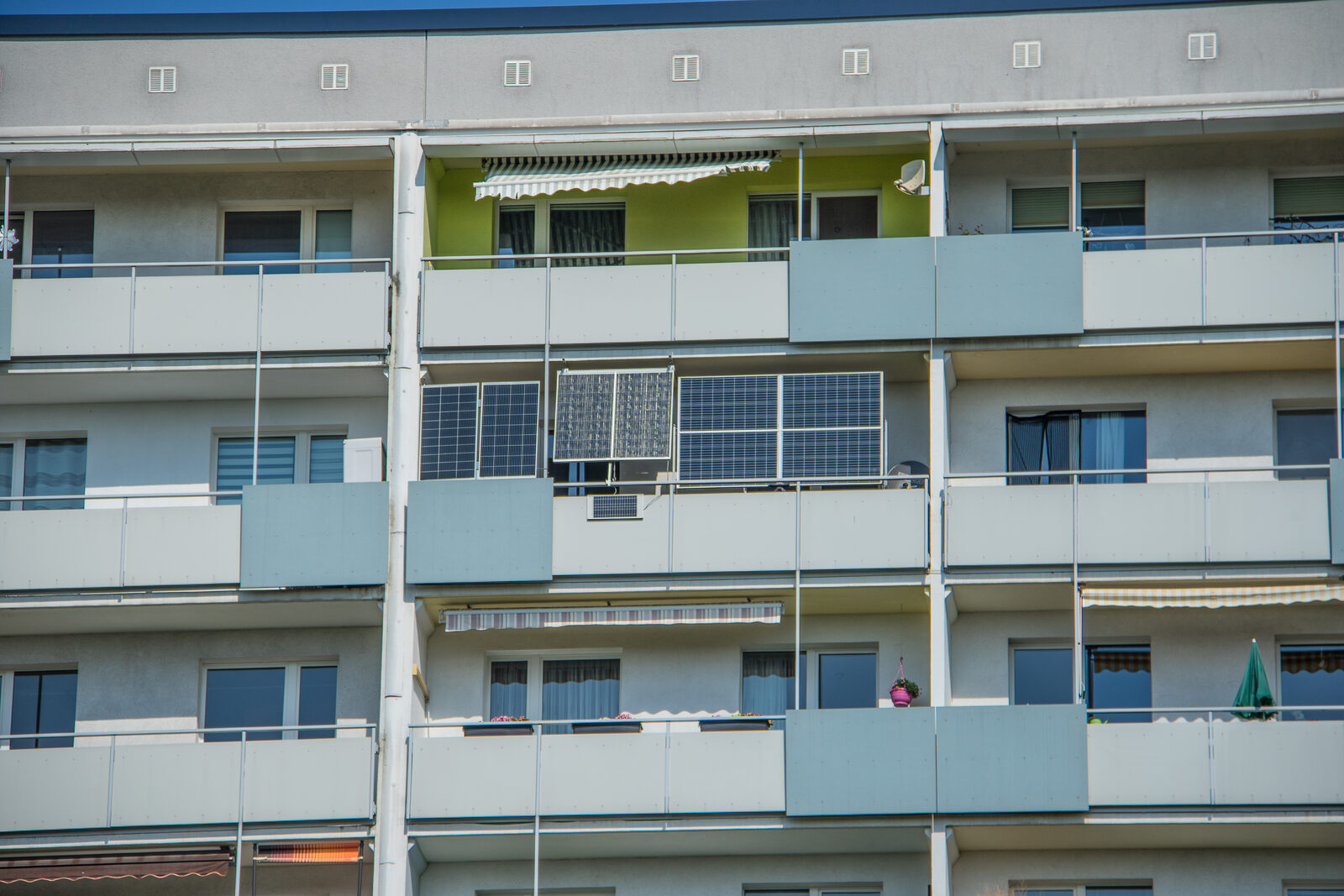 Mehrere Solarmodule von Balkonkraftwerken an den Balkonen eines Plattenbaus in Leipzig
