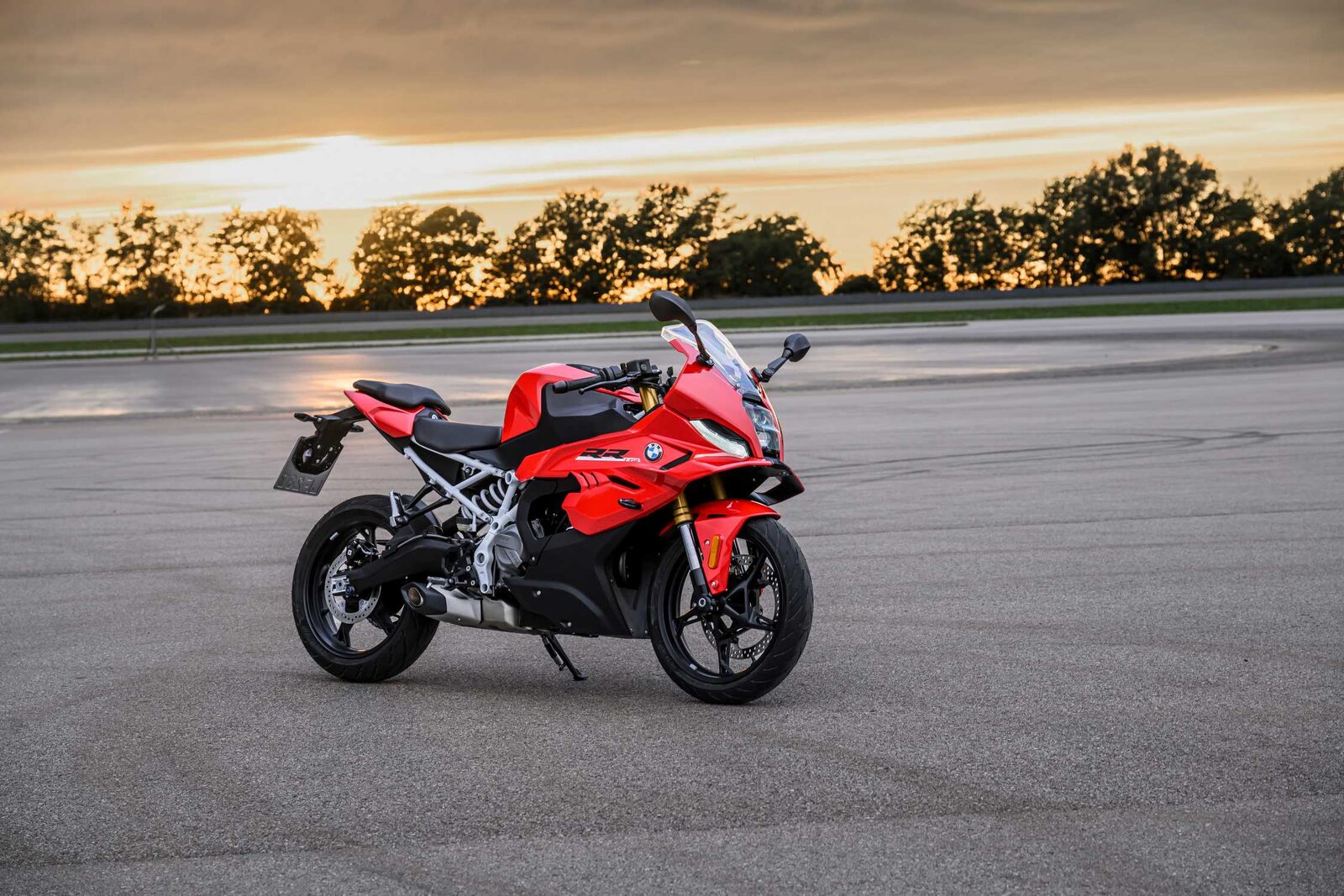 Kırmızı BMW F 450 RR, gün batımında boş bir pist alanında park halinde
