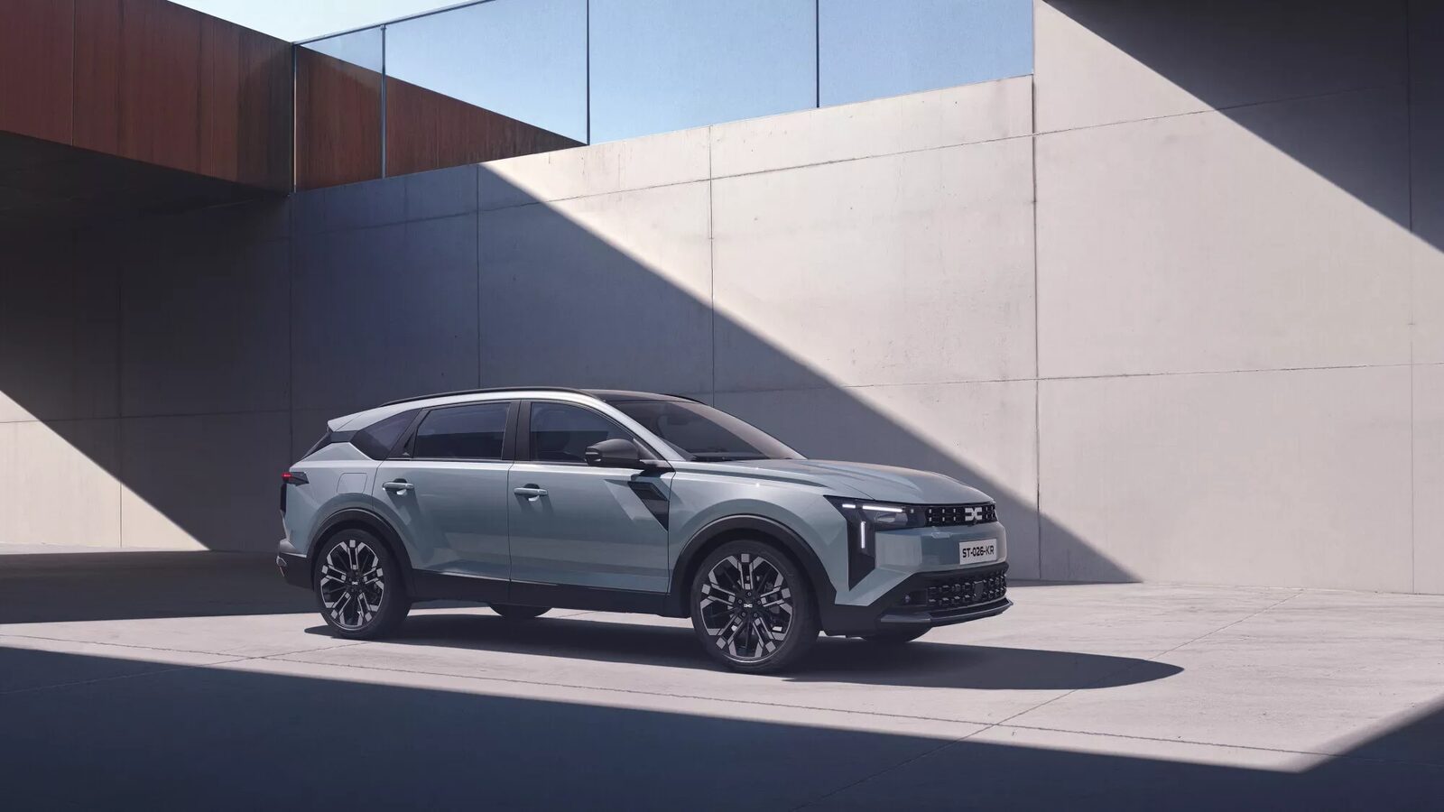 Gri-mavi Dacia Striker beton bir yapının gölgesinde önden çapraz açıyla duruyor