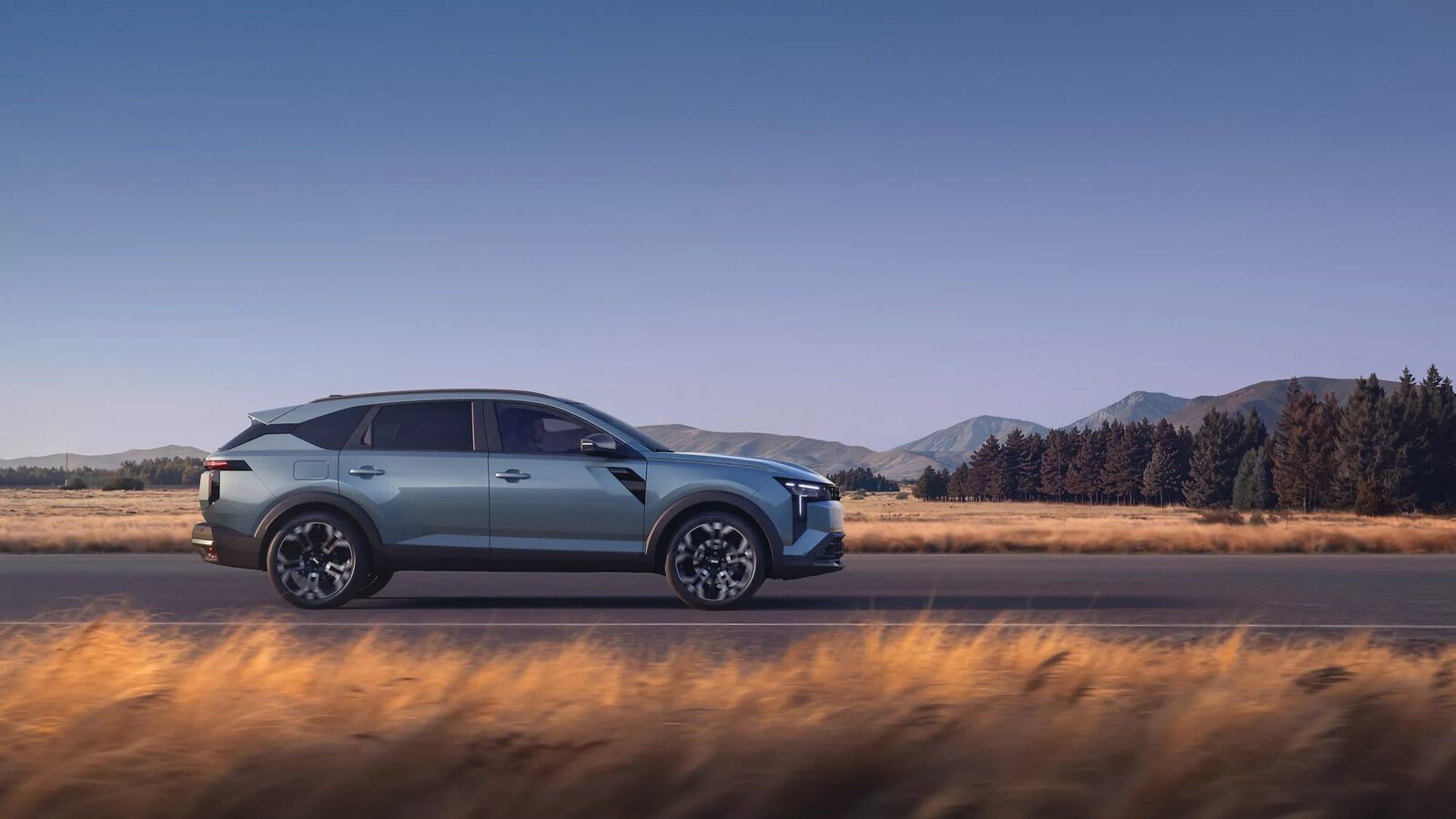 Gri-mavi Dacia Striker kırsal bir yolda yandan görünüm