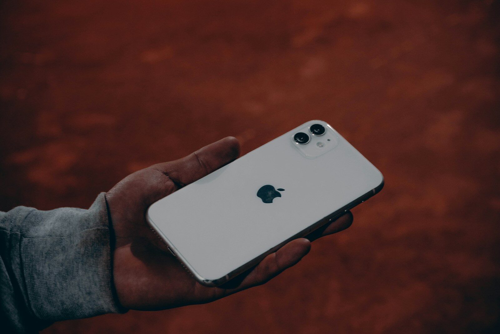 Avucunda arkası dönük beyaz bir iPhone tutan el