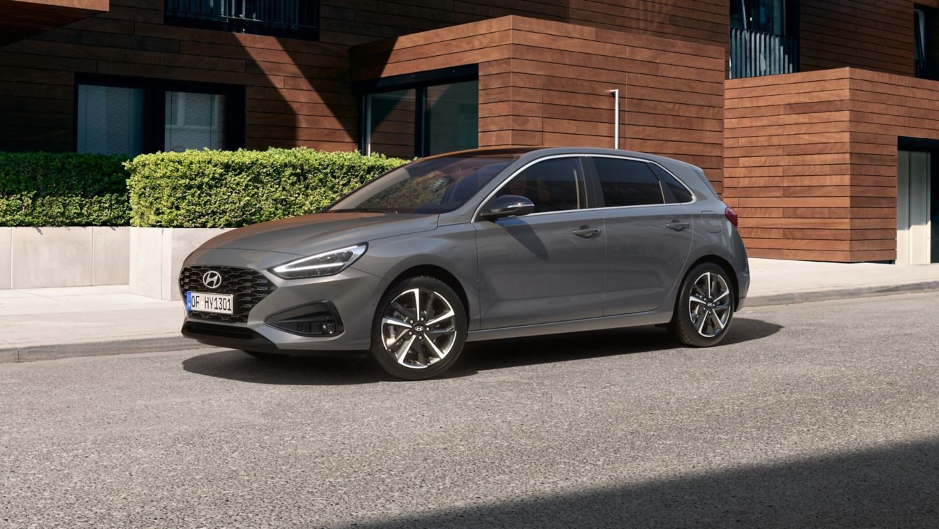 Gri Hyundai i30, modern bir evin önünde önden çapraz görünüm
