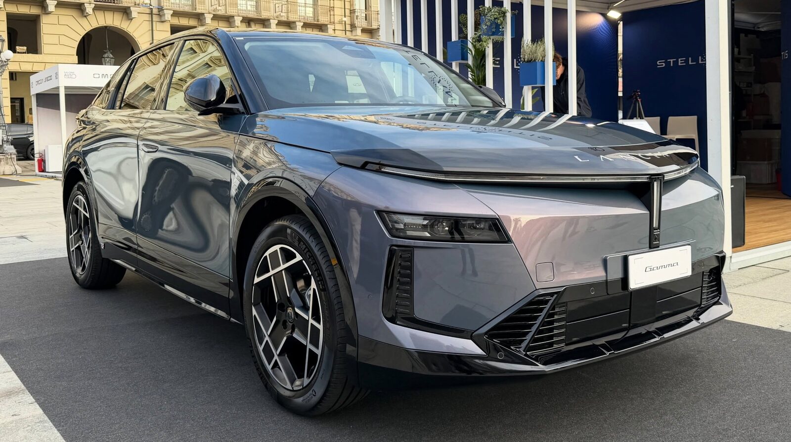 Lancia Gamma elettrica grigia vista di tre quarti anteriore in una piazza di Torino