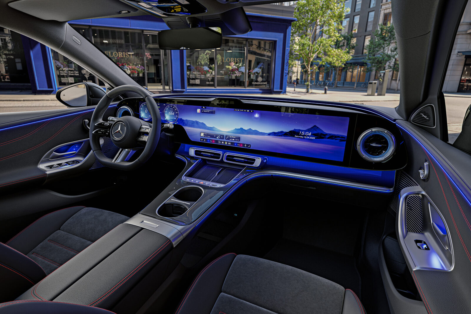 Elektrikli Mercedes C-Serisi'nin iç mekânı: göğüs boyunca uzanan MBUX Hyperscreen ve mavi ortam aydınlatması