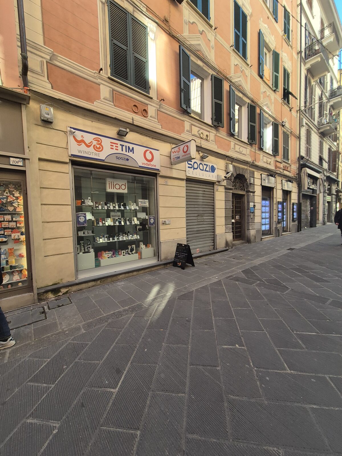 Negozio di telefonia a La Spezia con le insegne di WindTre, TIM e Vodafone sopra la vetrina