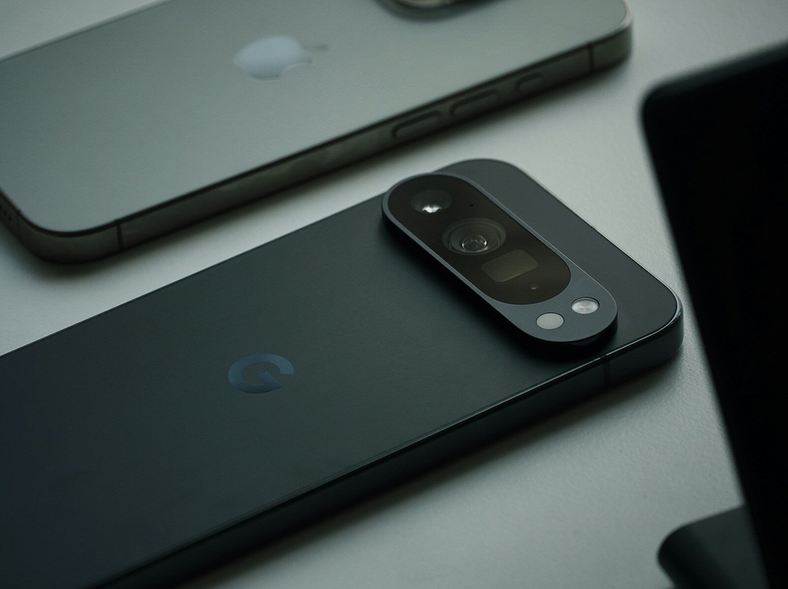 Ein iPhone und ein Google-Pixel-Smartphone liegen mit der Rückseite nach oben auf einem Tisch