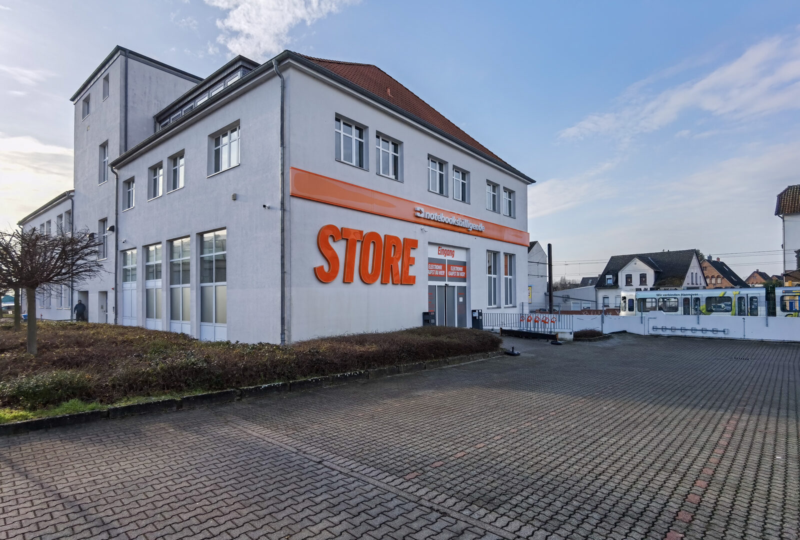 Außenansicht des Notebooksbilliger-Stores in Laatzen bei Hannover mit großem orangefarbenem Schriftzug „Store“