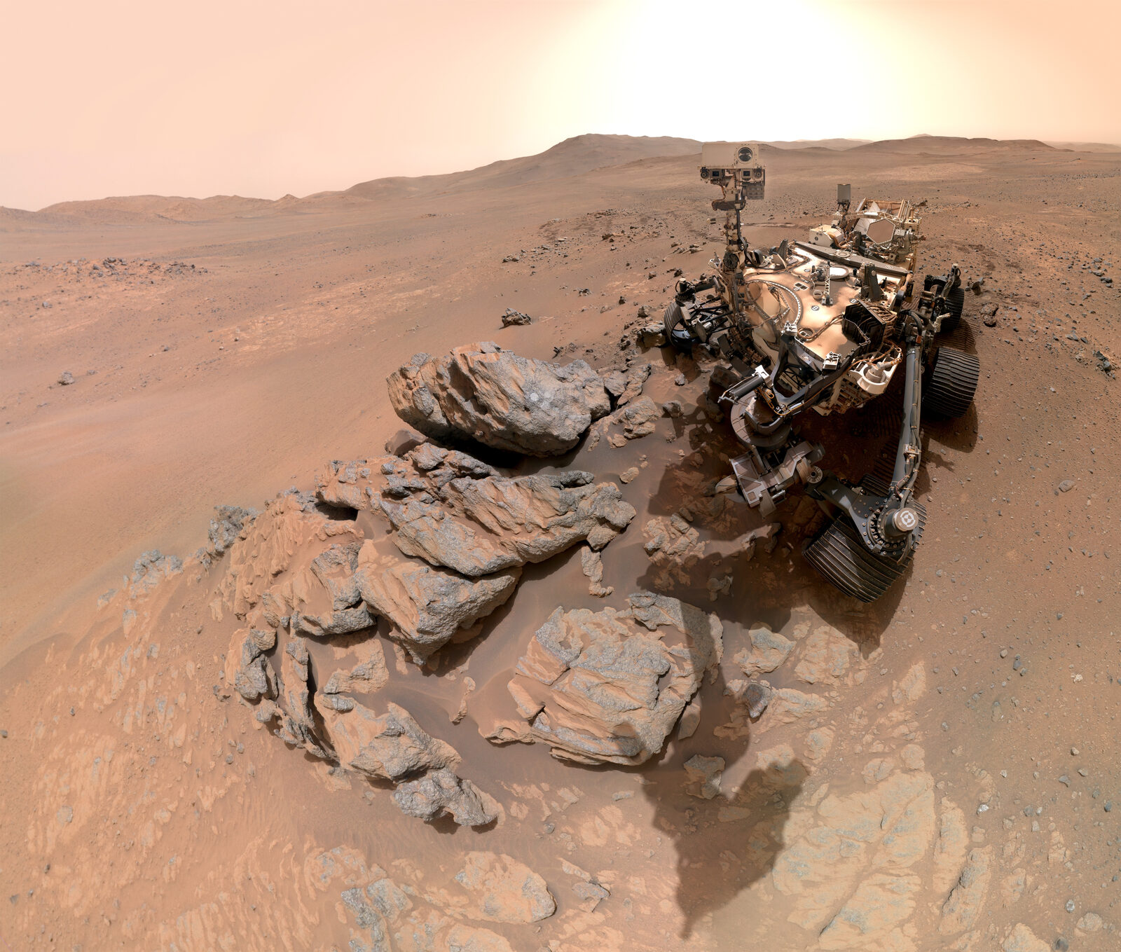 Selfie des Mars-Rovers Perseverance neben einem Felsausbiss, im Hintergrund der Rand des Jezero-Kraters