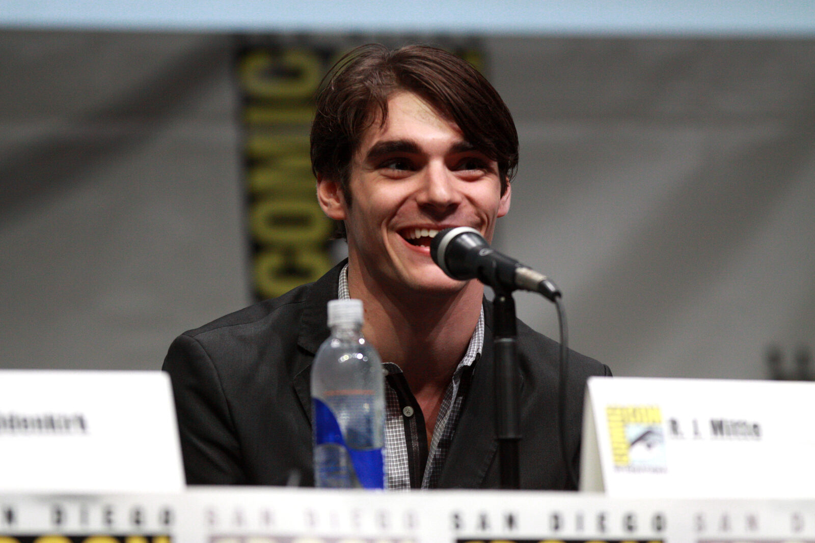 RJ Mitte, 2013 San Diego Comic-Con'daki Breaking Bad panelinde mikrofon başında gülümsüyor