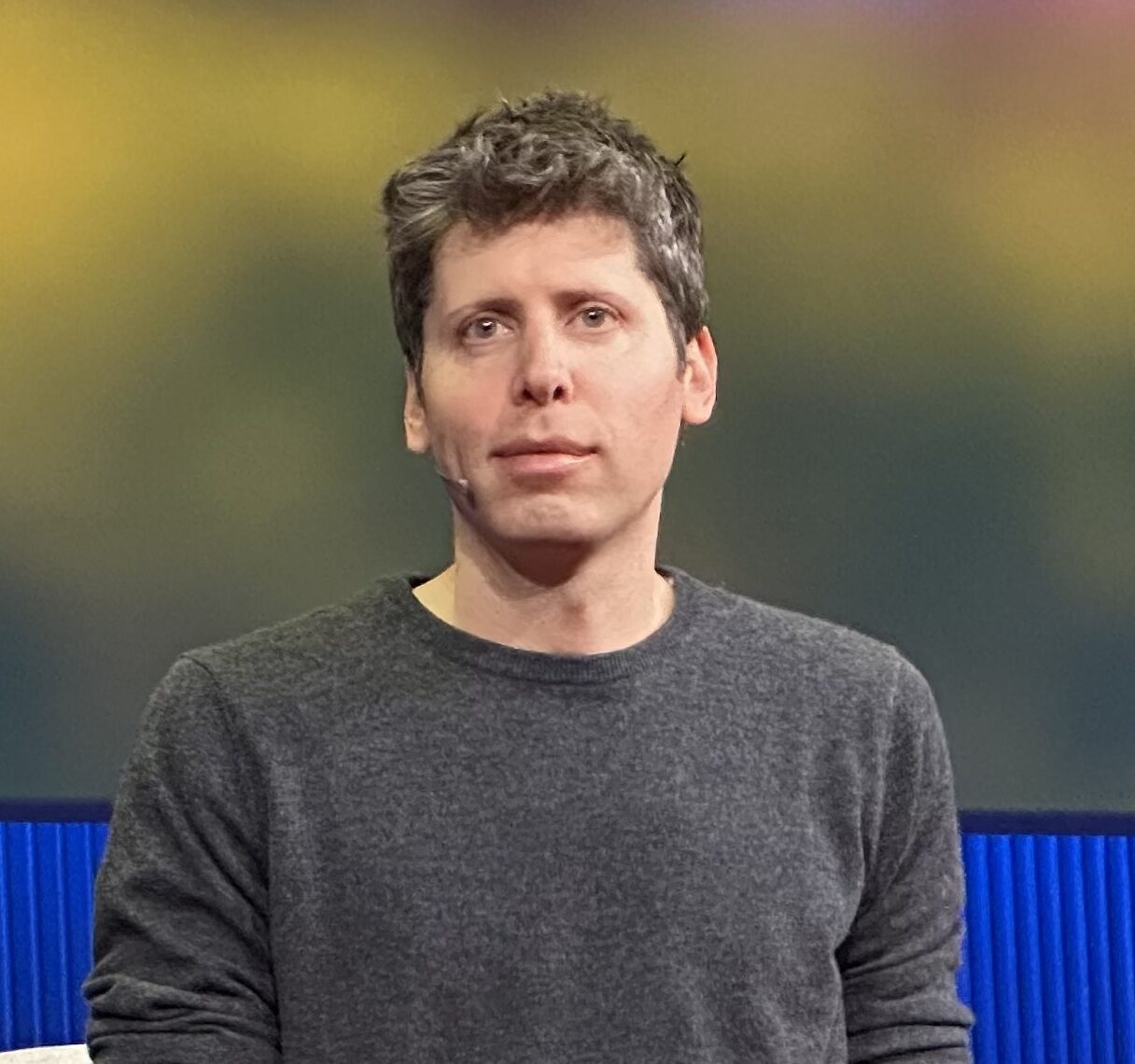 OpenAI-Chef Sam Altman im grauen Pullover auf einer Bühne