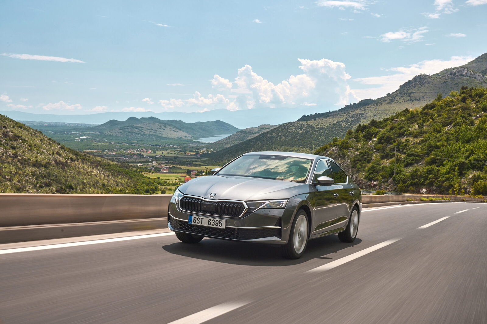 Dağlık bir yolda ilerleyen gri Skoda Octavia sedanın önden görünümü