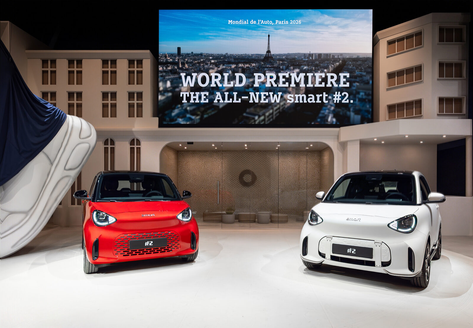 Una smart #2 rossa e una bianca sul palco del Mondial de l'Auto di Parigi sotto la scritta World Premiere