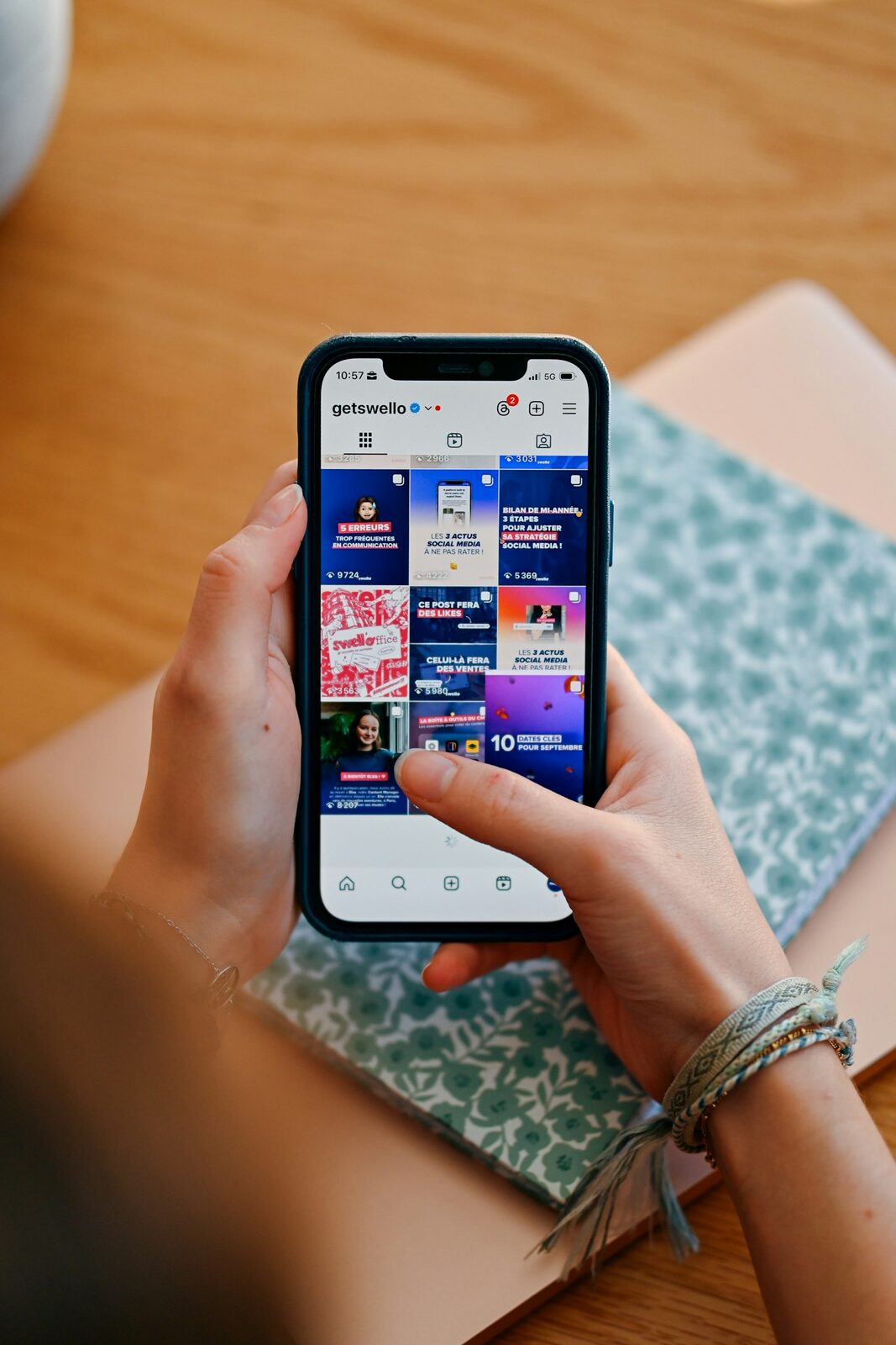Elinde akıllı telefon tutan bir kullanıcı, ekranda bir sosyal medya profilinin gönderi akışı