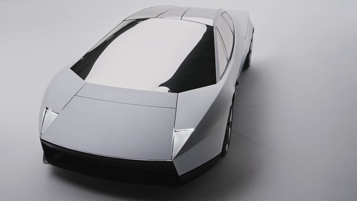 De nieuwe Tesla Roadster met hoekige carrosserie en spiegelend glazen dak, schuin van boven gezien tegen een grijze achtergrond