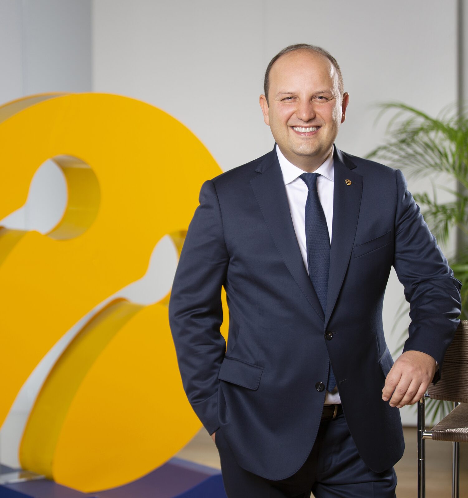 Turkcell'in şebeke teknolojilerinden sorumlu yöneticisi Prof. Dr. Vehbi Çağrı Güngör, sarı Turkcell logosunun önünde