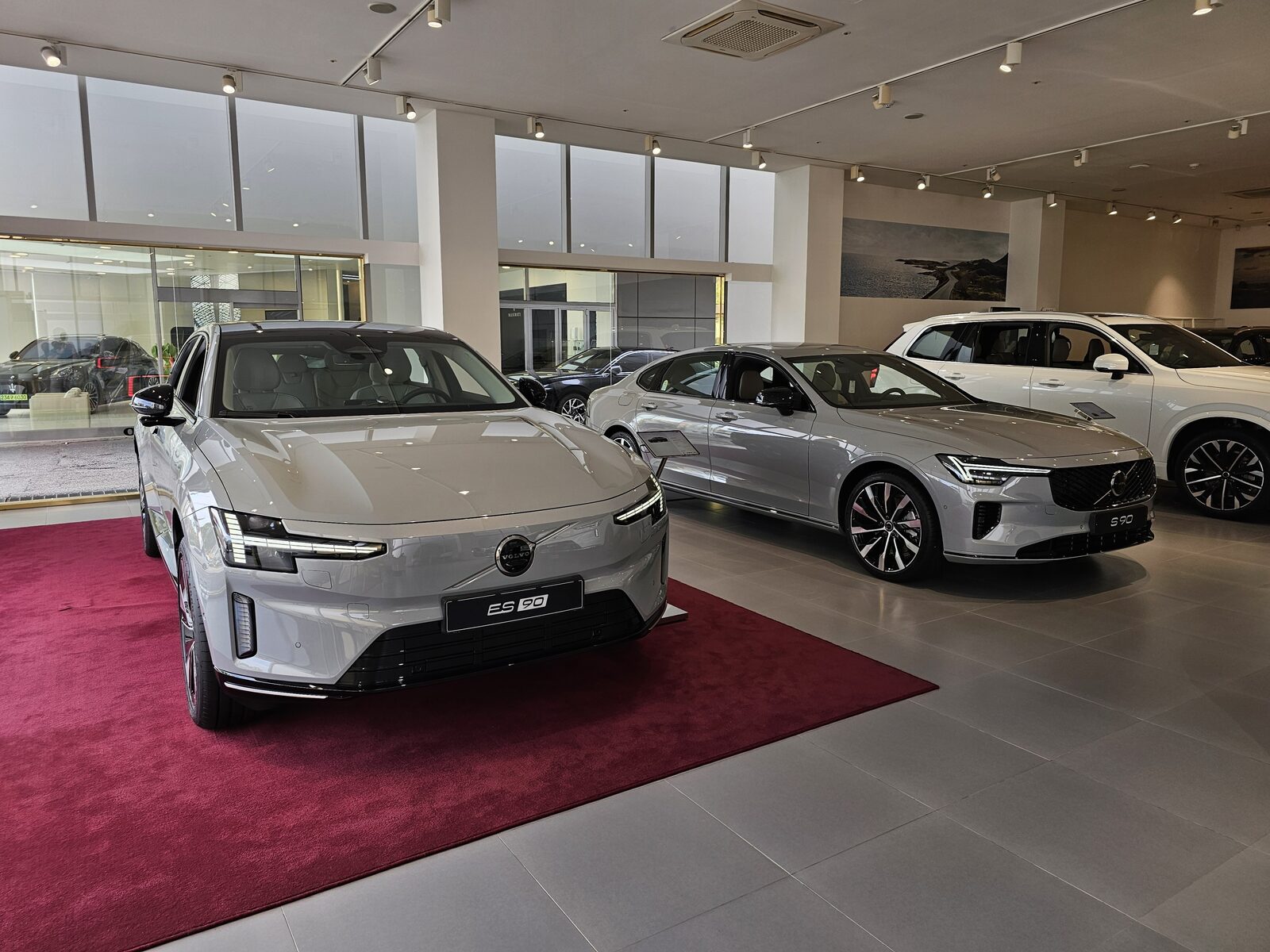 Vapour Grey renkli Volvo ES90 ile S90 sedan bir bayide yan yana duruyor